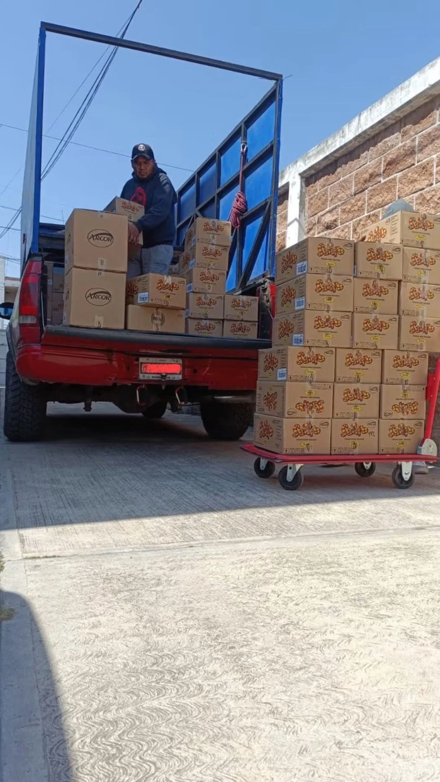 Carga de cajas en camioneta roja durante un servicio